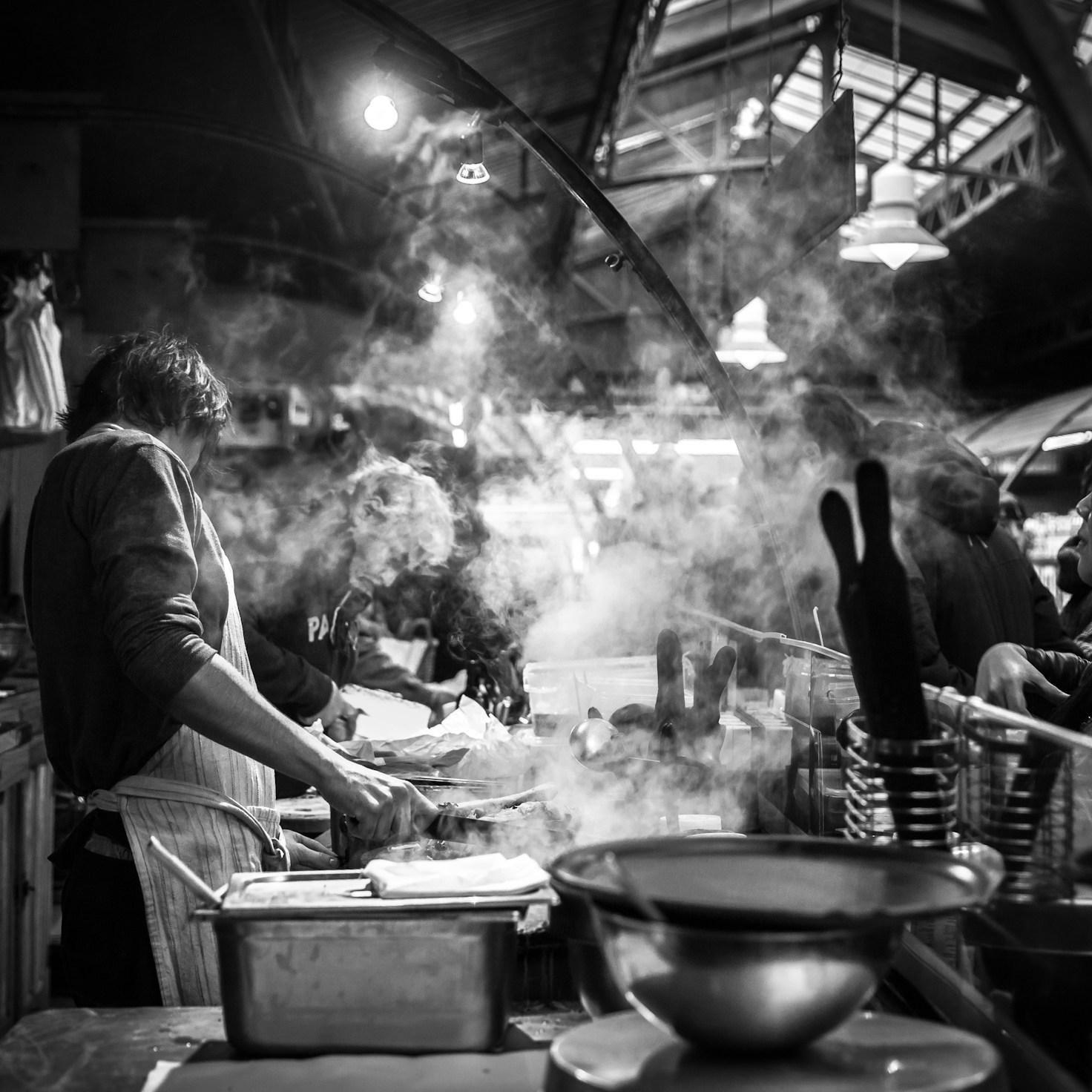 Community members collaborating in a contemporary kitchen, exchanging recipes and cooking techniques